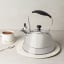Sagenwolf Stainless Steel Stovetop Kettle, 3L on trivet next to cup of tea