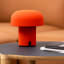 Kooduu Sensa Table Lamp - Orange on a coffee table