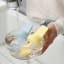 Zuutii Oil Dispenser with Brush, 130ml - Creamy Yellow in a bowl of water