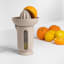 Blim Plus UFO Juicer with QB Jug - Moka Grey on the table with oranges