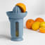 Blim Plus UFO Juicer with QB Jug - Ocean Dark on the table with oranges