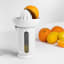 Blim Plus UFO Juicer with QB Jug - Arctic White on the table with oranges