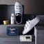 Gentlemens Hardware Sneaker Cleaning Kit on a shelf with shoes