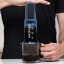 AeroPress Clear Blue Coffee Maker in use making a coffee