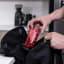 AeroPress Clear Red Coffee Maker being put into backpack