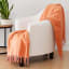 Linen House Coral Blossom Embrace Throw on a chair