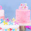 PME Multicolour Happy Birthday Candle - Pink on a cake