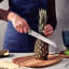 Tramontina Stainless Steel Bread Knife, 20cm slicing a pineapple