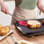 Tovolo Silicone Slotted Turner with Stainless Steel Handle - Viva Magenta flipping sandwich on press