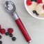 KitchenAid Coreline Ice Cream Scoop - Empire Red on the table