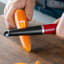 KitchenAid Coreline Euro Peeler - Empire Red peeling a carrot