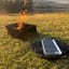 Pretzel Fire Pit with Carrier Bag and Grill - Black & Stainless Steel with fire on grass