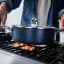 Joseph Joseph Space Ceramic Non-Stick Shallow Casserole Pan with Glass Lid and Folding Handle, 28cm on the stove