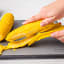 Dreamfarm Corn Peeler on a chopping board with corn