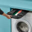 Joseph Joseph Hold-All Jonathan Lawes Collapsible Laundry Basket, 35L stored between the washing machine and shelf