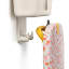 Joseph Joseph IronHub Wall-Mounted Ecru Iron Storage Caddy detail with an iron and ironing board