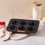 Le Creuset Non-Stick Mini Muffin Pan, 6-Cup angle on the kitchen counter