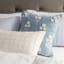 Thread Office Pale Blue Block Flower Embroidery Scatter Cushion with Feather Blend Inner, 50cm x 50cm on a bed with other scatters