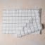 Mikasa Grey & White Industrial Check Table Runner, 230cm folded on a counter