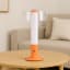 Arc & Hue Arcis Portable & Rechargeable LED Lamp - Orange on a coffee table
