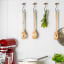 KitchenAid Birchwood Basting Spoon hung with other utensils on the kitchen hanger