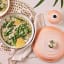 Le Creuset Peche Signature 5.3 Litre Round Cast Iron Casserole, 26cm with food on the table