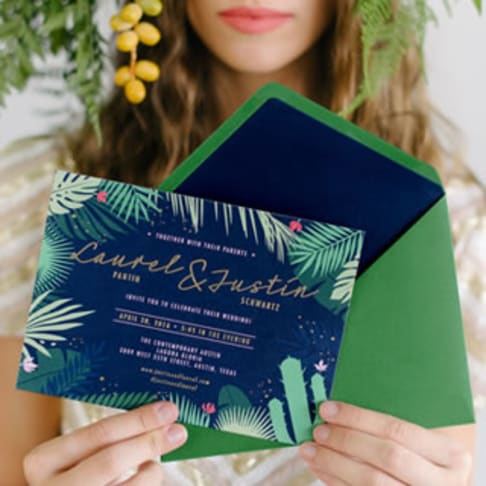 Person holding up a wedding invitation design