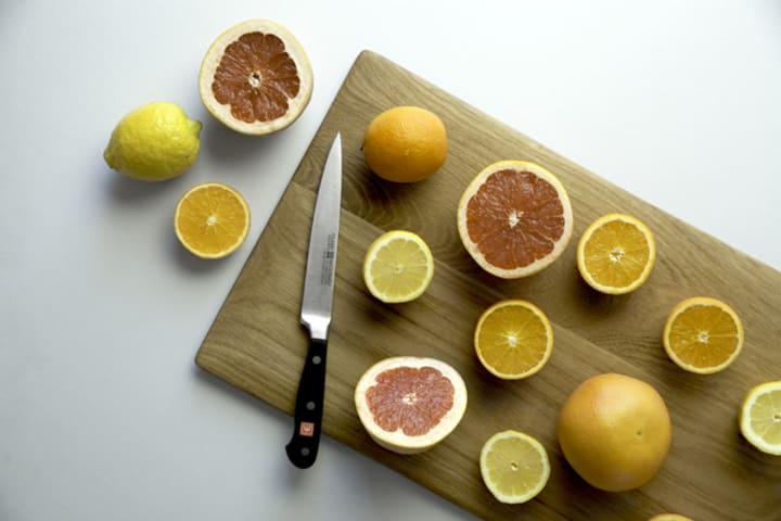 Utility knife on a chopping board with citrus