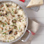 Le Creuset 3 Ply Non-Stick Stainless Steel Chefs Pan with food on the table