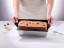 NoStik Reusable Cake Tin Liner, Rectangular with cake lifting out of loaf tin