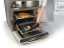 NoStik Reusable Oven Protector, in oven with melted cheese from pizza