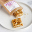 The Counter Salted Macadamia & Rosemary Brittle, 120g on a side plate