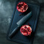 WÃ¼sthof Performer Hollow Edge Santoku, 17cm on a chopping next to chopped pomegranate 