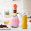 Smeg Personal Blender, 300W - Pastel Pink on the kitchen counter with blended juice and fruits