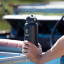 Kulgo Flask with Straw Cap, 1L - Black in hand by the truck