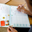 Crunchbox Menu Planner on the table writing a meal plan