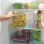 Joseph Joseph FridgeStore Shelf Divider in the fridge with stacked bottles of refreshments
