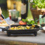 Ooni Cast Iron Sizzler Pan with Stainless Steel Trivet Base on the table with food