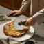 Eva Solo Green Tools Pizza Wheel on the table cutting pizza