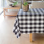 Linen House Revana Black Check Tablecloth with a plant on the table
