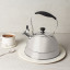 Sagenwolf Stainless Steel Stovetop Kettle, 3L on trivet next to cup of tea