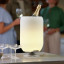 Kooduu Atmos Brass All-In-One Wine Cooler Speaker & Lamp with a champagne bottle
