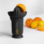 Blim Plus UFO Juicer with QB Jug - Carbon Black on the table with oranges