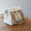 Pebbly Cotton Lunch Bag - Cream on the table