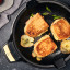 Victoria Signature Soft Seasoned Finish Double Handle Skillet, 33cm with food on the table