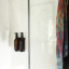 Joon Matte Black Adjustable Dispenser with Amber Bottle - Double on a wall in the shower