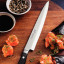 Tramontina Yanagiba Gold Sushi Knife, 23cm on a chopping board