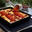 Ooni Detroit-Style Pizza Pan - Medium with food on an Ooni folding table