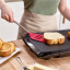 Tovolo Silicone Slotted Turner with Stainless Steel Handle - Viva Magenta flipping sandwich on press
