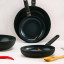 Cosy & Trendy Full Black Ceramic Non-Stick Wok, 28cm on the counter with other pans